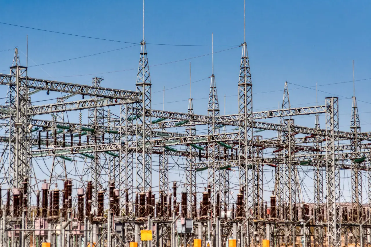 A large power plant with many towers and wires.
