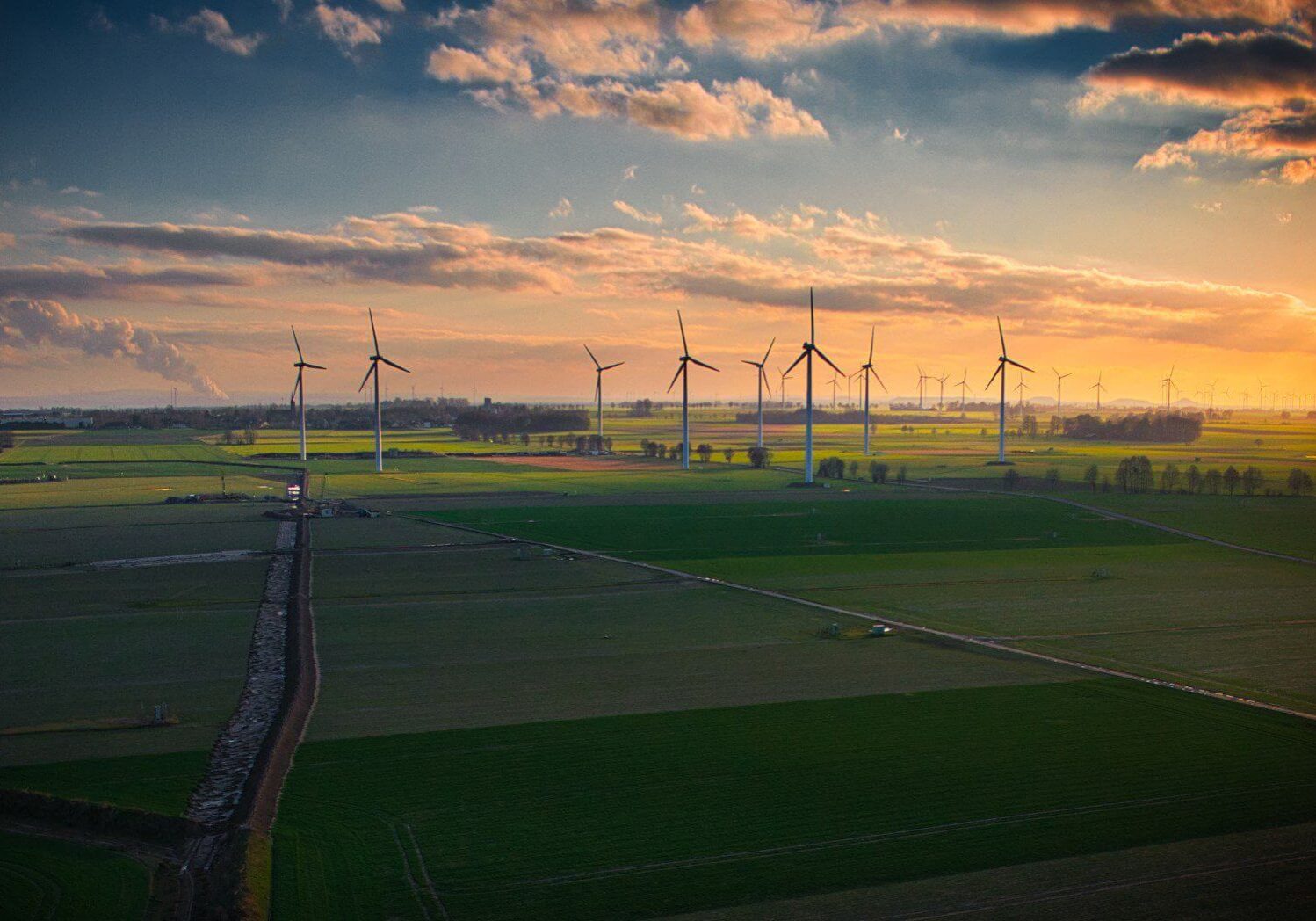 Sunset wind farm across patchwork fields