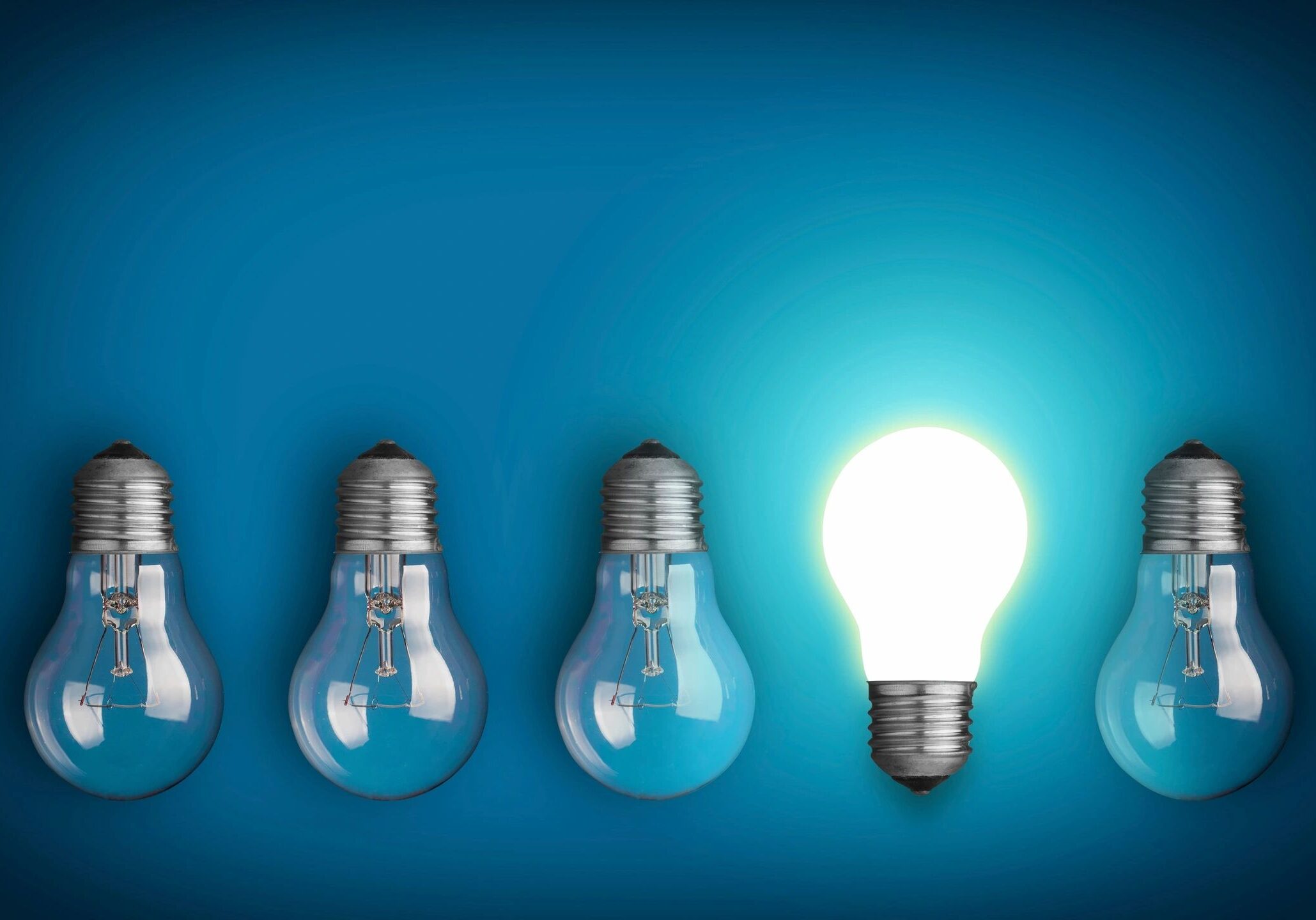 A row of light bulbs with one lit up.